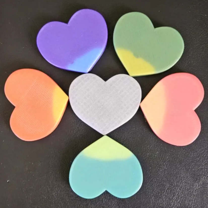3D printed heart-shaped fidgets made with thermochromic filament showing color changes