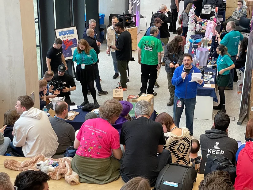 Joel Telling hosting the Ultimate Additive Manufacturing Quiz at SMRRF 2026 with attendees gathered around the stage area
