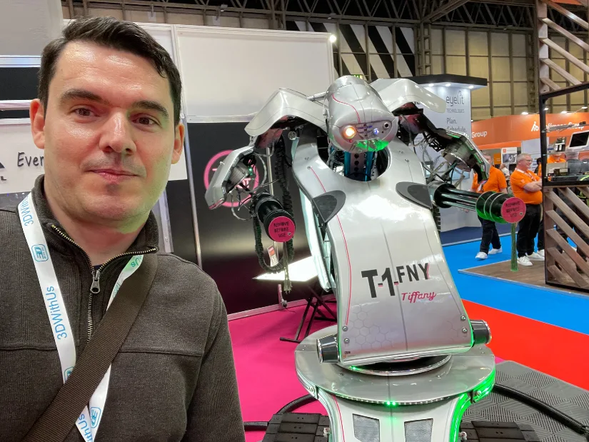 Max Funkner takes a selfie with T1FNY, a futuristic robotic installation at Smart Factory Expo, held alongside TCT 3Sixty 2025 at NEC Birmingham