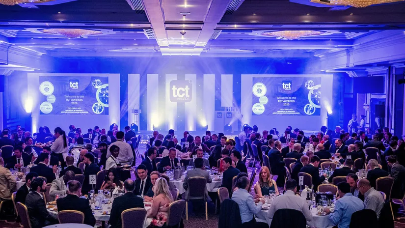 Guests seated at round tables during the TCT Awards ceremony in a formal banquet hall with stage and screens lit in blue