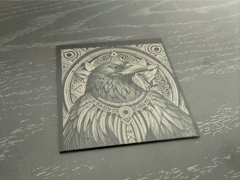 A highly detailed illustration of a raven on acrylic featuring ornate geometric patterns, a decorative bead necklace, and intricate motifs set against a contrasting background.