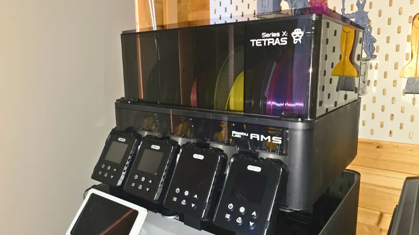 EIBOS Series X Tetras filament dryer attached to Bambu Lab AMS unit with multiple filament spools and screen modules displayed.