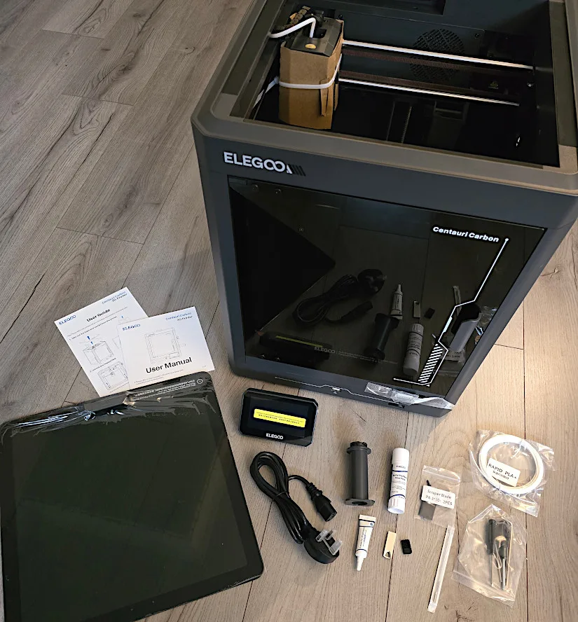 Elegoo Centauri Carbon 3D printer and included accessories laid out on the floor