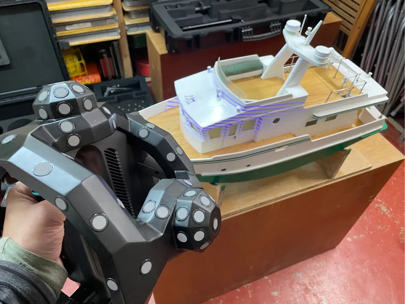 Scanning a detailed model boat using the Revopoint Trackit in Track Scan Cross Lines mode, with visible laser lines on the boat’s surface