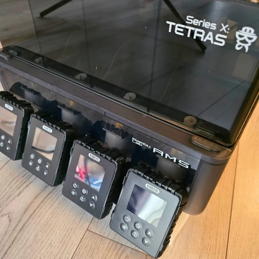 Front view of the fully assembled EIBOS Series X Tetras filament dryer attached to the Bambu Lab AMS, with four operational display screens installed.