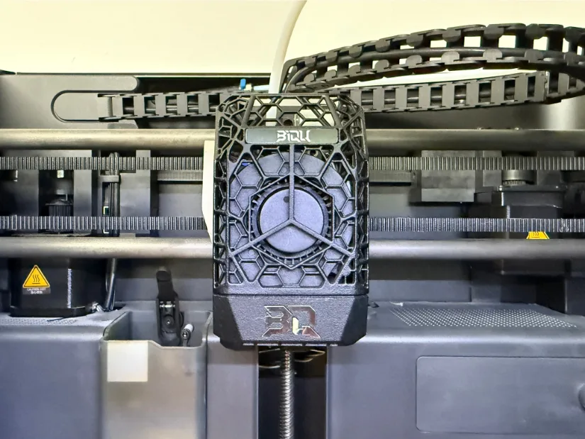 BIGTREETECH Panda JetPack auxiliary 5015 blower module with honeycomb lattice cover installed on a Bambu Lab P1S tool-head, framed by the printer’s belts and cable chain.