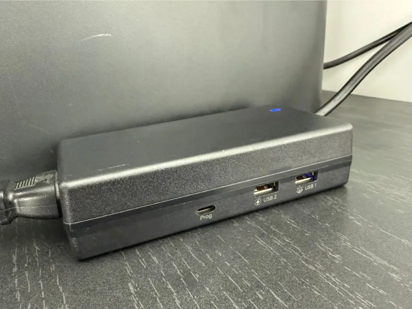 BIGTREETECH Panda PWR smart power-management hub on a desktop behind a Bambu Lab printer, displaying two USB-A ports, a USB-C programming port, status LED, and connected power cables.
