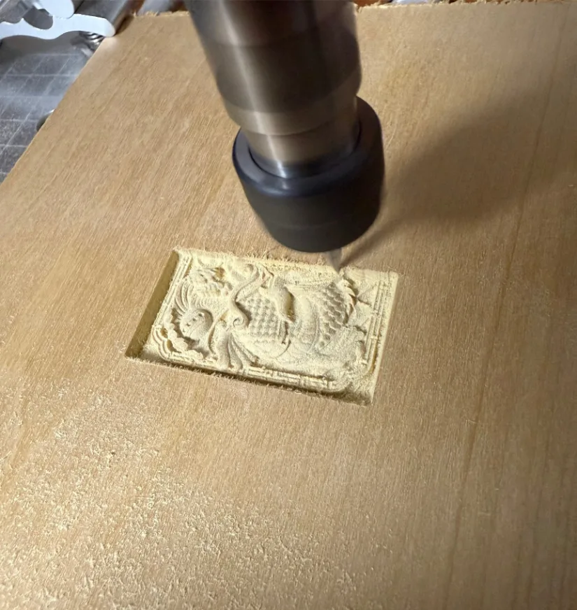 V-bit on the Lunyee 3018 Pro Ultra CNC router carving an intricate dragon relief into a poplar board.