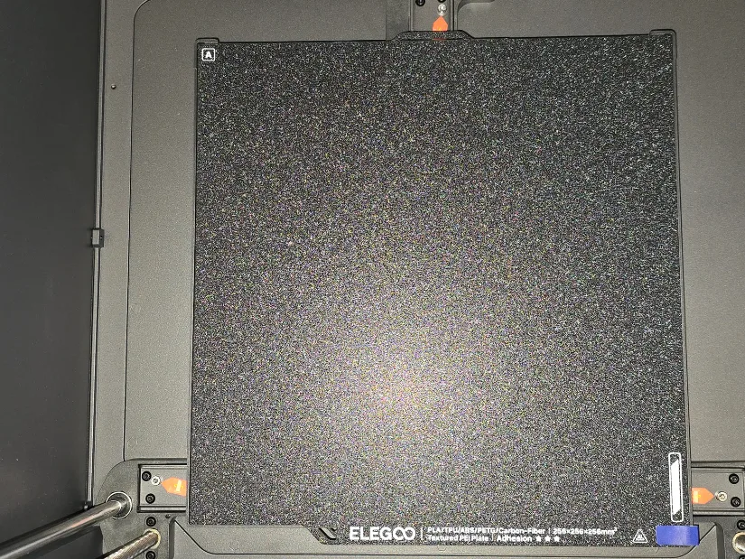 Top-down view of the Elegoo Centauri Carbon's textured PEI build plate with transport screws visible