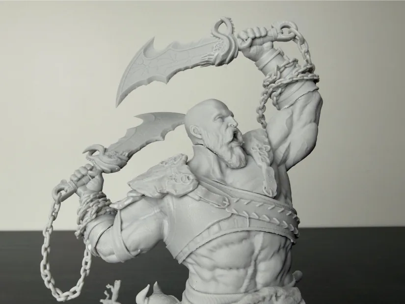 Close-up of Wicked3D Kratos resin statue—upper torso with raised blades and chains—unpainted gray print from Piocreat HALOT-X1 16K resin 3D printer showing sharp skin and armor textures
