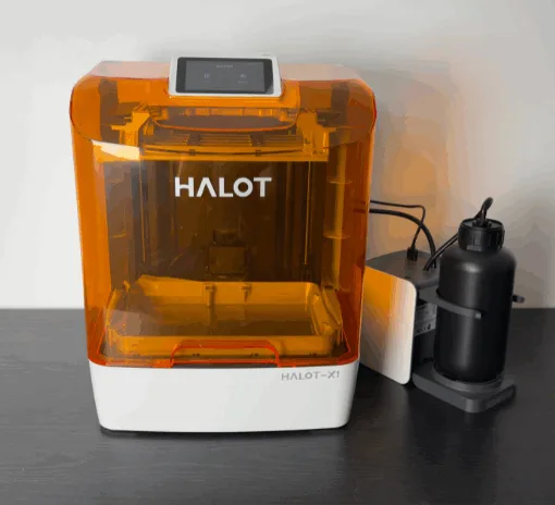 Piocreat HALOT-X1 16K resin 3D printer with amber cover and AFU (Auto Feed Unit) on the right, front view on desktop