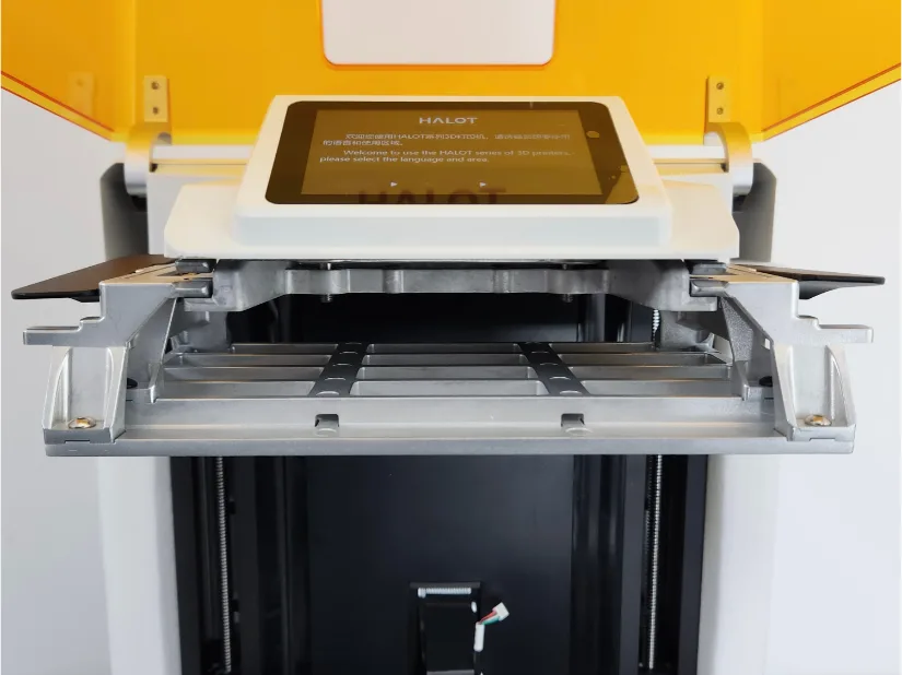 Piocreat HALOT-X1 interior close-up showing the solid-mount, leveling-free build platform with the lid open and touchscreen above