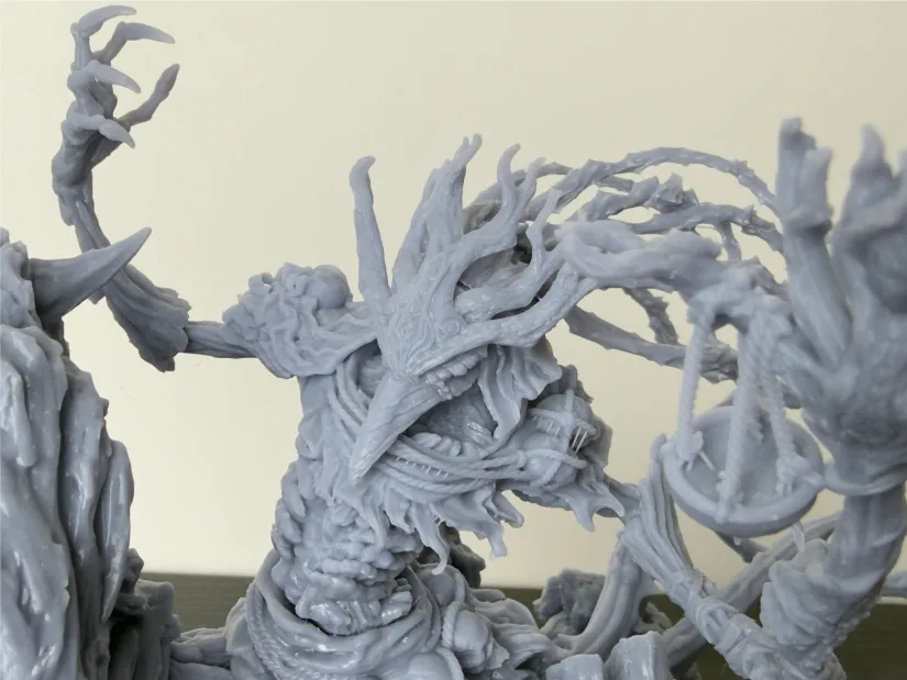 Close-up of Nerikson Famine Horseman resin print—spiked mask, tendrils, ribbed armor, and hanging scales—unpainted gray model from Piocreat HALOT-X1 resin 3D printer