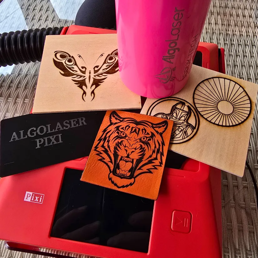 Laser engraved samples including wood, leather, aluminum card, and coated bottle created using the Algolaser Pixi