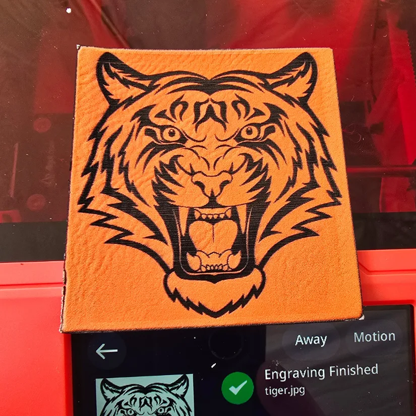 Tiger image engraved on orange scratch leather using Algolaser Pixi with completion screen visible underneath