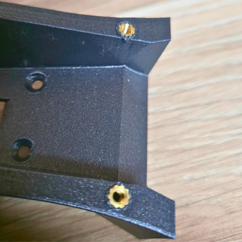 Close-up of brass inserts installed flush into a 3D printed PLA part using the Mintion Heat Press Kit