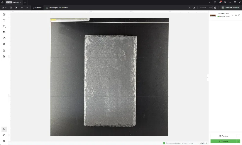 Screenshot of xTool Creative Space (XCS) showing the main workspace with a photographed slate tile on the bed, grid overlay, left toolbar, layer/device panel on the right, and “Framing/Process” controls.