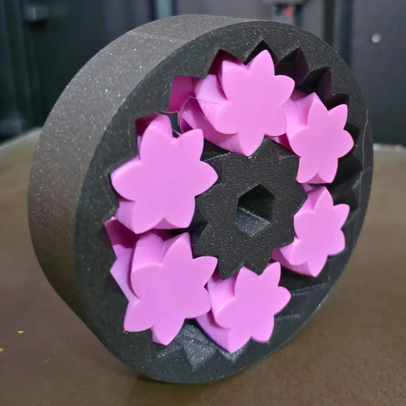 Multi-color cogwheel 3D print in pink and black on the Prusa XL showing precise tolerances