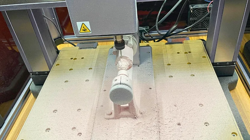 Snapmaker 4-axis CNC carving the Lion test object from Luban in original Snapmaker material block, showing heavy dust build-up halfway through the job