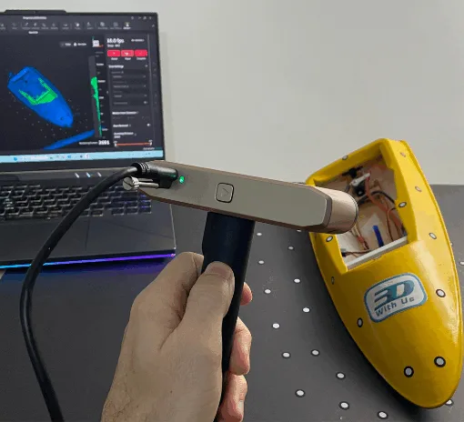 Scanning a yellow RC model boat using the Revopoint Inspire 2 3D scanner connected to a laptop with Revo Metro software