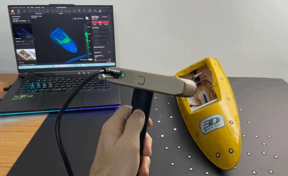 Scanning a yellow RC model boat using the Revopoint Inspire 2 3D scanner connected to a laptop with Revo Metro software