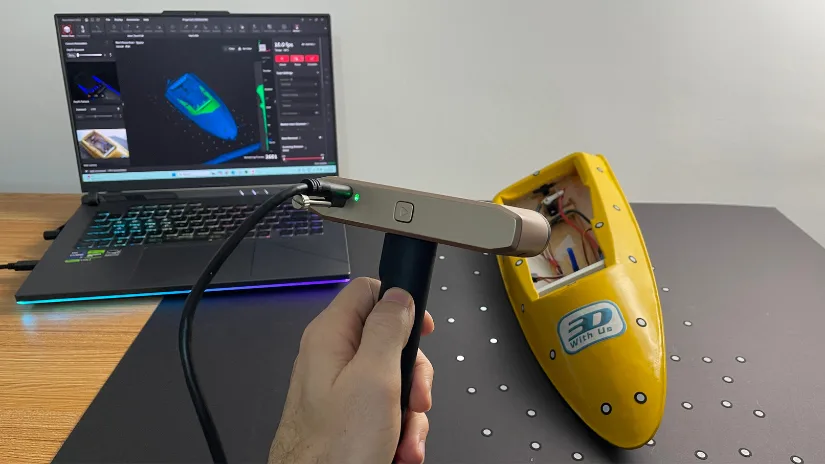 Scanning a yellow RC model boat using the Revopoint Inspire 2 3D scanner connected to a laptop with Revo Metro software