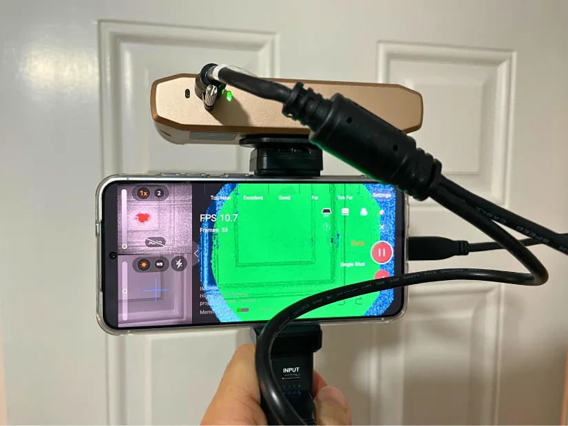 Revopoint Inspire 2 3D scanner mounted on a smartphone using the mobile kit while scanning a door surface