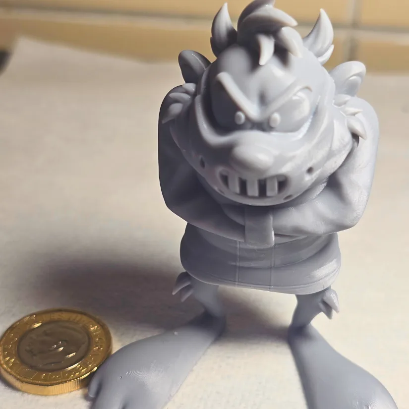 Grey resin Looney Tunes character 3D printed on the Uniformation GK3 Pro shown next to a coin for scale