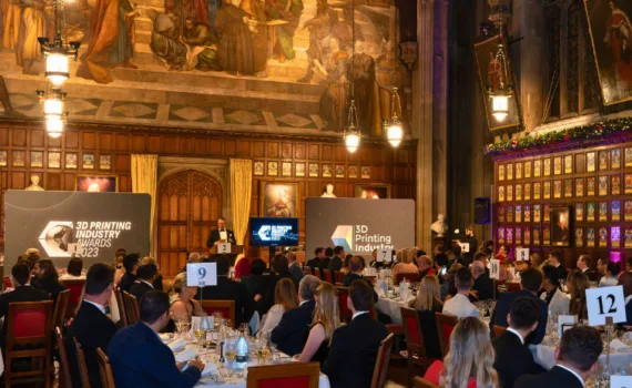 Audience and stage at the 3D Printing Industry Awards 2023 ceremony with attendees seated at tables during the awards presentation