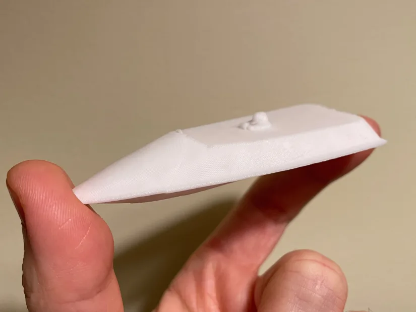 3D printed miniature of RC boat created from a Revopoint INSPIRE 2 scan, shown resting on fingertips.