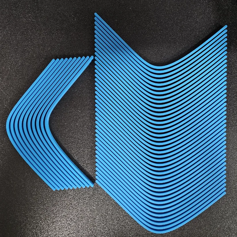Multiple 3D printed exponential curve models arranged closely together on a build plate for efficient batch printing.