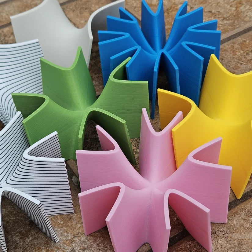 3D printed saddle surface models in multiple colors, including monkey and higher-order saddles, used to visualize saddle points in multivariable calculus