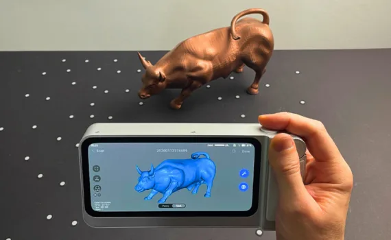 3DMakerpro Toucan handheld 3D scanner capturing a Charging Bull 3D printed model with the scan result shown on the device screen