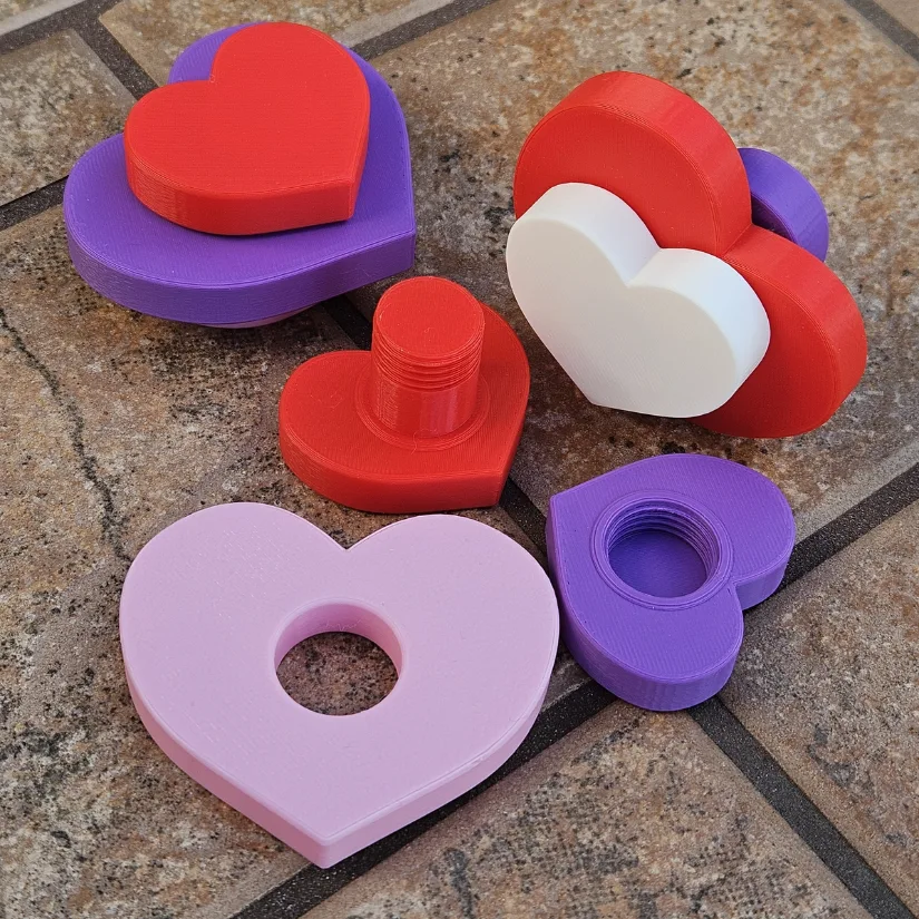 3D printed heart-shaped components of a triple heart fidget spinner shown before assembly