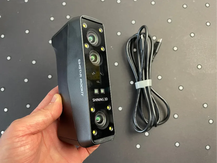 EINSTAR Rockit 3D scanner front view showing camera array and USB cable on a marker board surface
