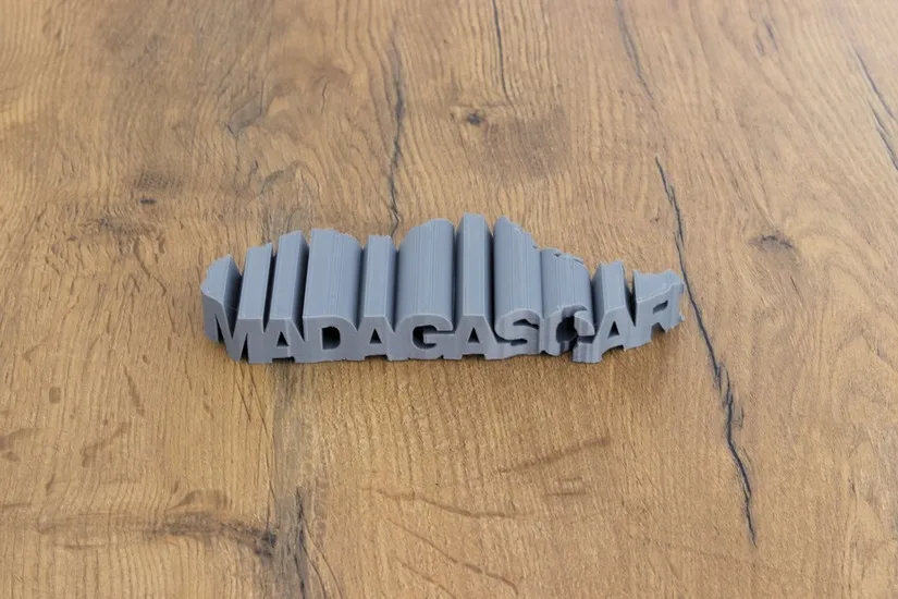 Finished MADAGASCAR text-flip 3D print combined with a map shape on a wooden surface
