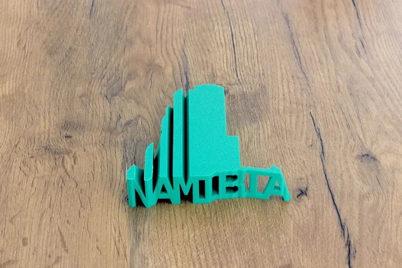 Finished word-to-shape text-flip 3D print on a wooden surface