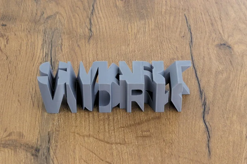 Finished word-to-word text-flip 3D print on a wooden surface