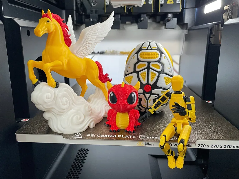 Multicolor 3D printed models including Pegasus, Cute Dragon, Mecha Snake Egg and Dummy 13 on Snapmaker U1