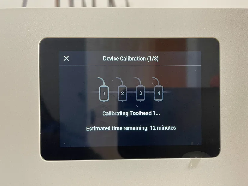 Touchscreen showing toolhead calibration process with estimated time remaining