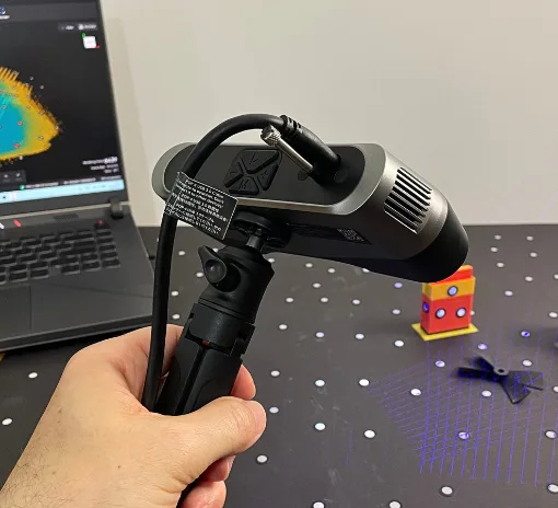 Revopoint POP 4 scanning a black broken propeller with blue laser lines