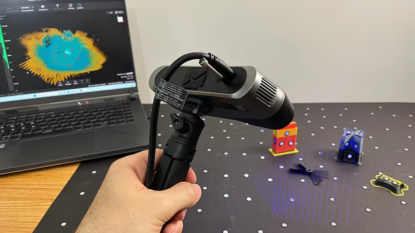 Revopoint POP 4 scanning a black broken propeller with blue laser lines