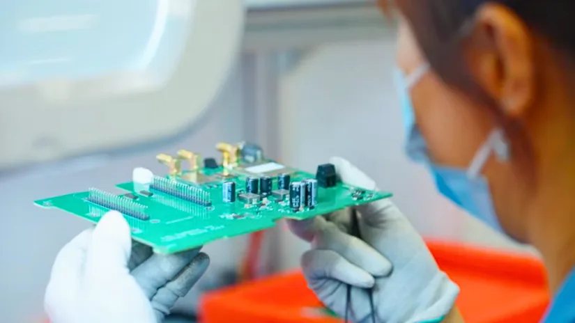 Technician inspecting an assembled printed circuit board for Bittele Electronics PCB assembly services