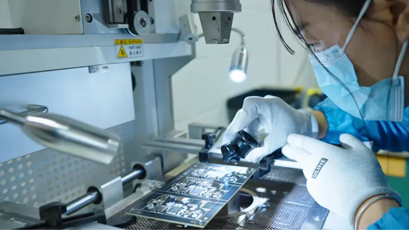 Technician inspecting printed circuit boards during quality control process