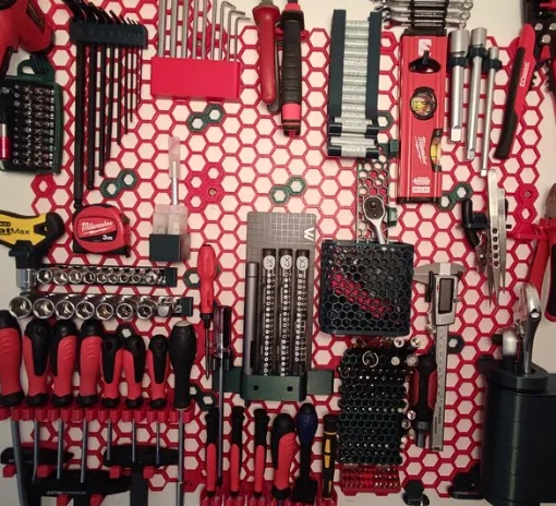 3D printed Honeycomb Storage Wall with mounted workshop tools, screwdrivers, drill bits, sockets, and holders