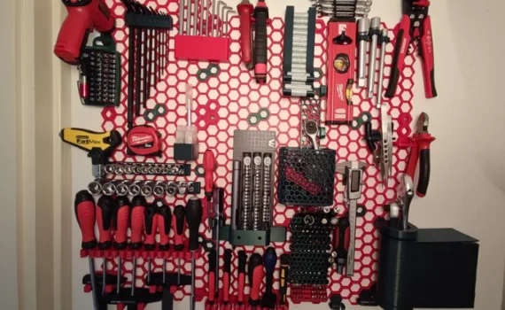 3D printed Honeycomb Storage Wall with mounted workshop tools, screwdrivers, drill bits, sockets, and holders