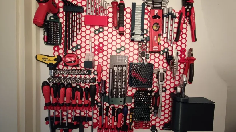 3D printed Honeycomb Storage Wall with mounted workshop tools, screwdrivers, drill bits, sockets, and holders