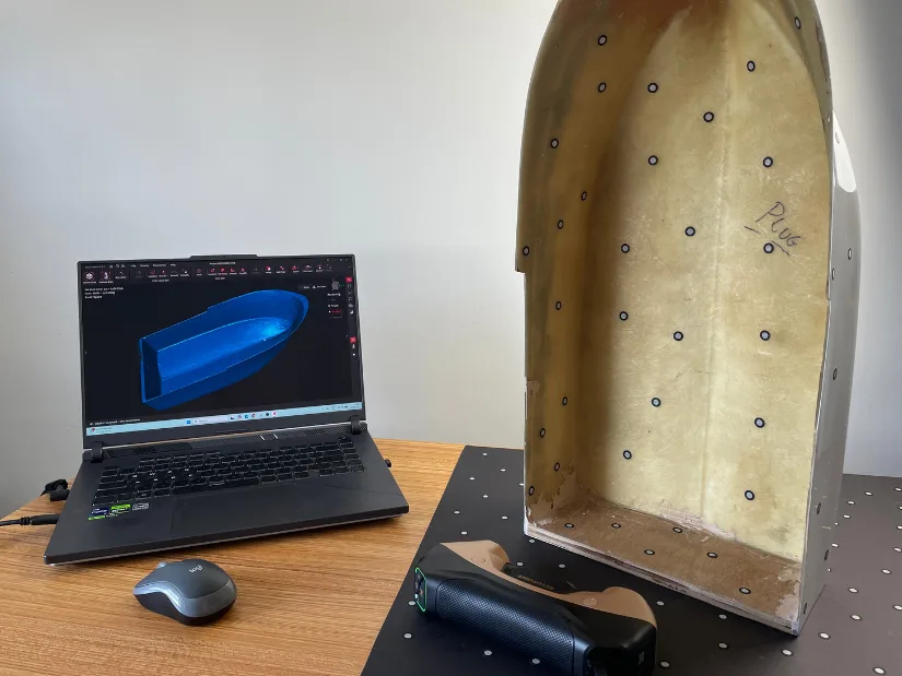 Scanning a complete RC boat hull in a single scan using marker targets. Laptop and scanner on the table.