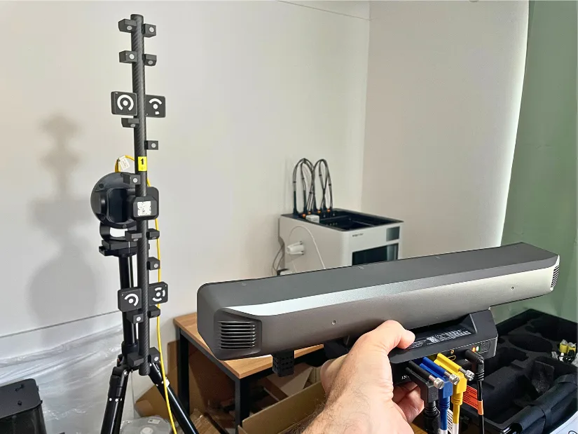Revopoint Trackit SR being held in front of the calibration pole and automatic gimbal during calibration.