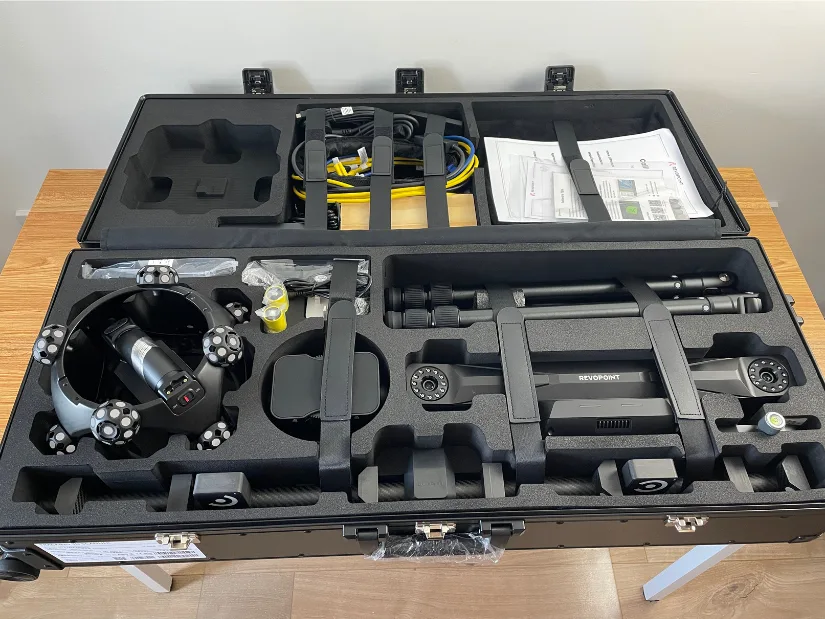 Revopoint Trackit SR 3D scanner kit stored in its open protective case with tracker, tripod, calibration pole, batteries, cables, and accessories.